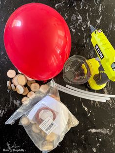 a red balloon sitting on top of a table next to a yellow blow dryer