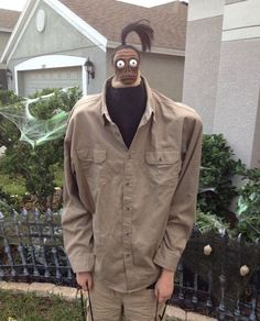 a man wearing a mask and carrying a bag with a face on it's head