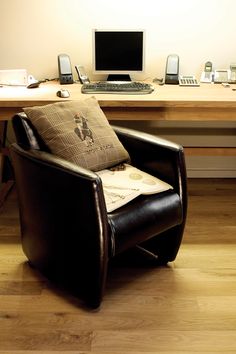 a chair sitting in front of a desk with a computer on it