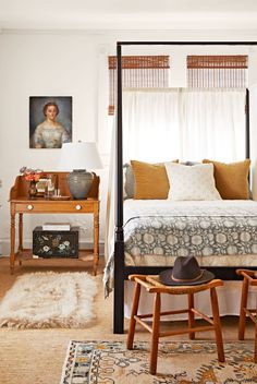 a bedroom with a four poster bed and white walls