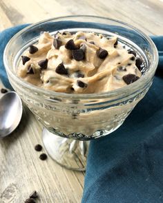 a glass bowl filled with ice cream and chocolate chips on top of a wooden table