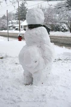 a snowman made to look like it is standing in the snow next to a fire hydrant