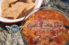 a bowl of chicken tortilla soup with tortilla chips on the side