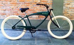 a green bicycle parked next to a brick wall