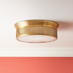 a light that is on the ceiling in front of a red wall and pink walls