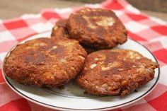 three fried patties on a plate sitting on a red and white checkered tablecloth