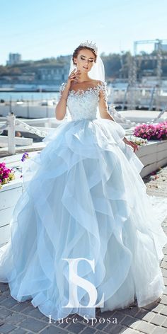 a woman in a wedding dress posing for the camera with her hand on her face