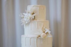 a white wedding cake with flowers on top