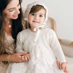 Baby girl with mom wearing Penelope knit baptism sweater and bonnet. White Lace With Long Sleeve Patchwork, White Lace With Long Sleeves And Patchwork, Fall White Lace Top, Fall Cream Lace Top With Lace Trim, Cream Lace Top With Lace Trim For Fall, White Lace Top With Lace Cuffs For Fall, Fall Wedding Lace Top, Fitted Off White Lace Top, Unique Baptism Gifts