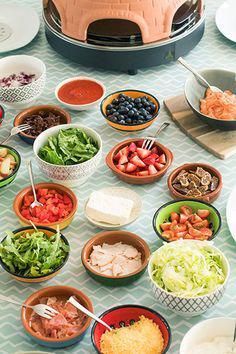 a table topped with bowls filled with different types of salads and dips next to an air fryer