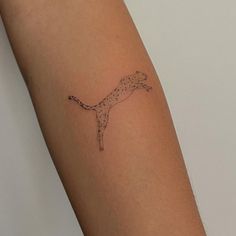 a woman's arm with a small tattoo of a cheetah