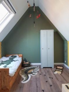 an attic bedroom with green walls and wooden floors