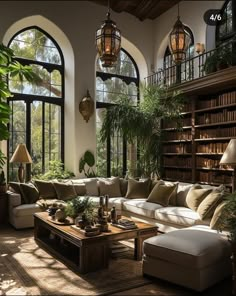 a living room filled with lots of furniture and large windowed windows next to a bookshelf