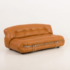 a brown leather couch sitting on top of a white floor