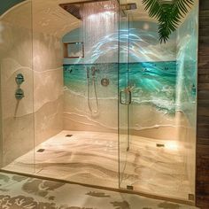 a bathroom with a glass shower door and an ocean scene painted on the wall behind it