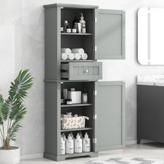 the bathroom cabinet is painted gray with white accents