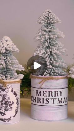 three tin cans with christmas trees in them