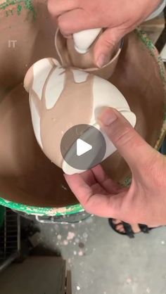 a person is making something out of clay in a bowl with their thumb on it