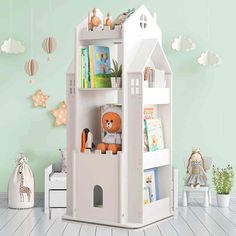 a white wooden doll house with bookshelf and stuffed animals