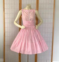 Vintage 1950s Early 60s Pink Peppermint Cupcake Bombshell Pin Up Rockabilly Dress.   1950s Barbie Doll Style Dress Pink peppermint stripe cotton party dress Nipped waist Full Gathered skirt White buttons on bodice Horizontal pleats at the waist Pink metal zipper in back Ties on the side to form bow in back Very wide hem Label: JONATHAN LOGAN In fabulous vintage condition --absolutely fabulous for it's age!! one little mark on the side and on tiny dot in back shown in last 2 photos--may wash out Vintage Sleeveless Dress For Tea Party, Spring Retro Petticoat, Vintage Pink Petticoat For Party, Pink Vintage Petticoat For Parties, 1950s Style Pink Vintage Dress, 1950s Barbie, Cotton Party Dress, Full Gathered Skirt, Outstanding Outfits