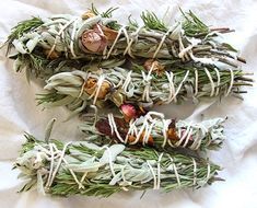 four bundles of dried herbs are laid out on a white sheet