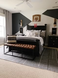 a bed room with a neatly made bed and a bench in front of a window