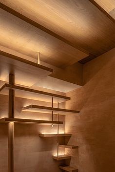 an empty room with wooden shelves and lights on the ceiling is lit by recessed lighting