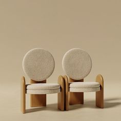 two chairs made out of wood and white upholstered fabric with circular cushions on them