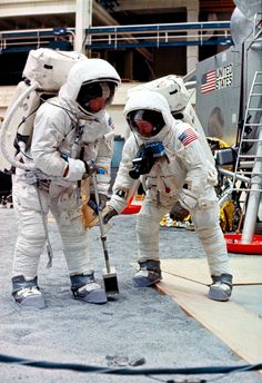 two men in space suits standing next to each other