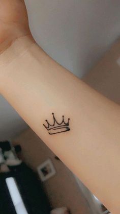 a small crown tattoo on the wrist