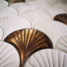 several white and gold fan shaped plates on display