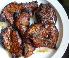 some meat is sitting on a white plate