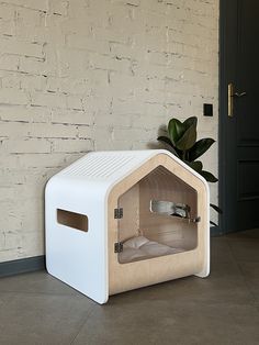 a small white bed sitting in front of a brick wall next to a potted plant