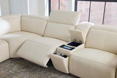 a white leather couch with an electronic device in the middle of it's back