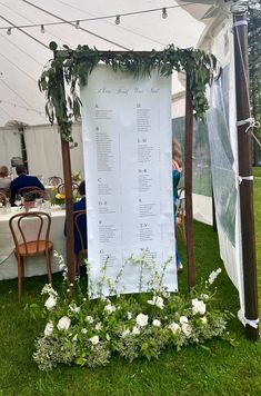 an outdoor seating area is set up with flowers and greenery on the grass for a wedding reception