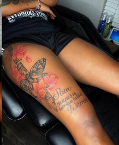 a woman sitting in a chair with a tattoo on her leg and the words pan de vaqueros written below it