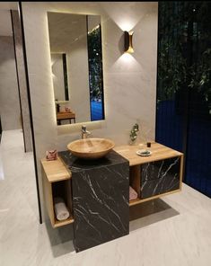 a bathroom with a sink, mirror and lights on the side walk in front of it