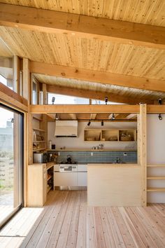 an open kitchen and living room with wood flooring on the inside of the house