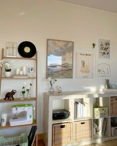 a living room filled with lots of furniture and pictures on the wall next to bookshelves