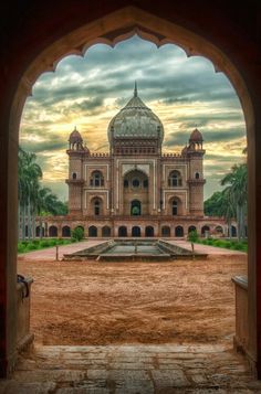 an archway leading to a large building with a fountain