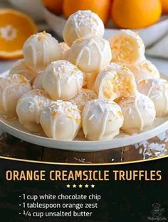 orange creamsice truffles on a white plate with an orange in the background