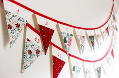 a red and white banner with christmas decorations on it's sides hanging from the wall