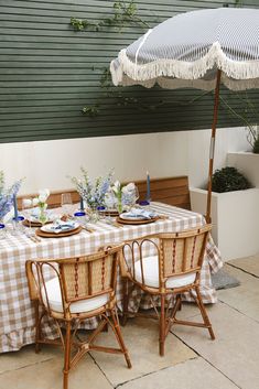 the table is set with an umbrella over it and plates are sitting on the table