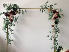 an arch decorated with flowers and greenery for a wedding or reception ceremony is displayed on the wall