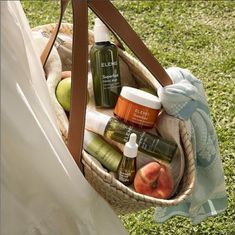 a woman holding a basket full of skin care products in her hand and an apple on the other side