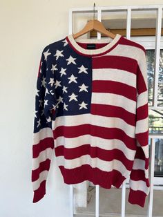 This American flag sweater features a bold stars and stripes design in classic red, white, and navy blue. Made with a cozy knit, it has a ribbed crewneck, cuffs, and hem for added comfort. Perfect for showing your patriotic style, adding a retro vibe to your wardrobe, or making a statement. Great for casual wear, themed events, or cozy layering in cooler weather. Very Good Condition Size: no tag, but fits a Large, (nice to wear a little oversized, so good too if you're a medium) Measurements lay Blue Sweater Men, White And Blue Sweater, White And Blue Outfits, Red White And Blue Outfits, Flag Sweater, Winter Pullover, Themed Events, Sweater Men, Blue Outfit