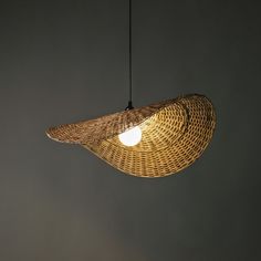 a light that is hanging from the ceiling with wicker material on it's sides