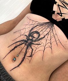 a woman with a spider web tattoo on her back