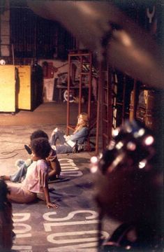 children sitting on the ground in front of a store