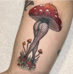 a woman's leg with a mushroom tattoo on her thigh and legs in fish net stockings